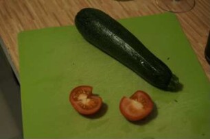 Zucchini und Tomate auf Schneidebrett
