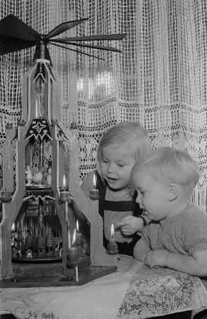 Zwei Kinder vor einer Weihnachtspyramide