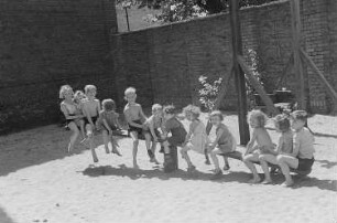 Betriebskindergarten der VEB Stralauer Glaswerke : Kinder auf einem Spielplatz auf einer Wippe
