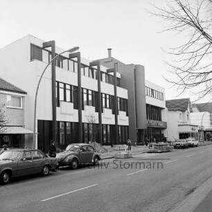 Kreissparkasse Stormarn, Zweigstelle: Hamburger Straße: Neubau bei Fertigstellung: Außenaufnahme: davor Herrichten des Gehsteigs: Stapel mit Betonplatten, Absperrung: Fußgänger, parkende Autos: rechts daneben Geschäft J. Braun, rechts außen Kaufhaus Nessler