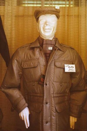 DDR. Schaufensterpuppe, wahrscheinlich in einem Exquisit-Laden, mit Schiebermütze, leichtem Schal und Importkutte (295 Mark der DDR)