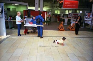 Sparkasse Holstein: Hauptstelle in der Hagenstraße: Halle im Erdgeschoss: Besucher am Bücherstand zur Kindervogelschießenausstellung des Kreisarchivs, am Tisch Archivmitarbeiter Manfred Holzgreve