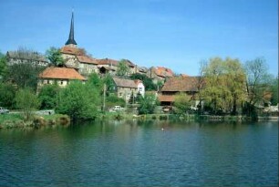 Blick von SW über den Teich zum Ort, Kirche ragt durch exponierte Lage und spitzen Kirchturm weit heraus