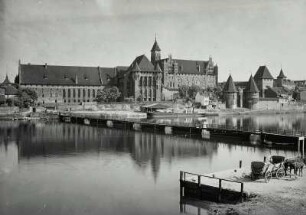 Marienburg, Stadtansicht : Marienburg (Malbork/Polen). Ordenschloss und Brücktor. Blick über die Nogat mit Schiffsbrücke nach Südosten