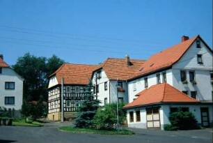 Dorfplatz mit denkmalgeschützten Wohnhäusern, vorn ehemalige Schmiede, Nr. 6