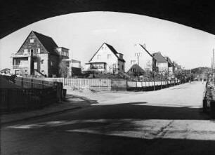 Coswig, Straßenansicht Hohensteinstraße. Blick durch die Eisenbahnbrücke nahe Bahnhof Neucoswig gegen Wohnhäuser mit Einfriedung