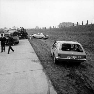 A 1: bei Stapelfeld: Verkehrsunfall: Pkw rammt Pkw und prallt gegen Brückenpfeiler: rechts neben Fahrbahn Unfall-Pkw auf Wiese, hinten zweiter Unfall-Pkw, vorne Bremsspuren: links auf Straße zwei Polizisten, zwei Abschleppwagen: oben rechts Böschung, obenauf Zäune