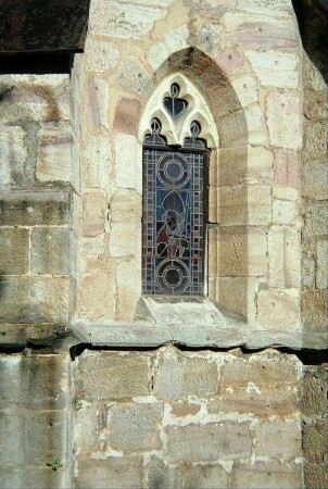 kleines, spitzbogiges Kirchenfenster mit Darstellung des Hl. Kilian (der Heilige der Franken)