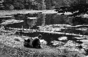 Sitzender Wanderer am Ufer des nonnenmattweihers bei Neuenweg