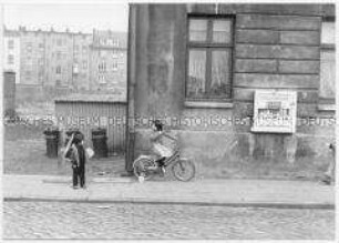 Zwei Kinder vor einer Hausfassade (Sonderthema: Kein Platz für Kinder)