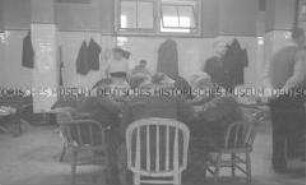 Selbstversenkung des Hochseepassagierdampfers "Columbus" am 19. Dezember 1939, Besatzungsangehörige im Internierungslager auf Ellis Island, an einem Tisch sitzend