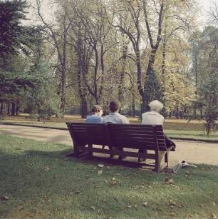 Dresden. Spaziergänger auf einer Parkbank im Großer Garten