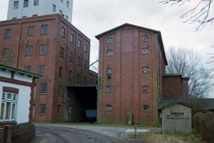 Lasbek-Barkhorst: Mühlenweg 3: Barkhorster Mühle W. F. Stoltenberg: links Mühlengebäude aus Backstein: rechts altes Silogebäude aus Backstein, davor alte Tankzapfsäule: dazwischen Unterfahrt: im Hintergrund links modernes Silo: im Vordergrund links Ecke von Wohnhaus: vorne Auffahrt auf Betriebsgelände, rechts altes Wachhäuschen mit Hinweis zu Kontor: 26. Januar 1999