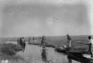 An einem Gewässer : Expeditionsteilnehmer in Kanus auf einem Gewässer