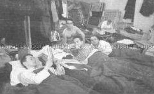Selbstversenkung des Hochseepassagierdampfers "Columbus" am 19. Dezember 1939, Besatzungsangehörige im Internierungslager auf Ellis Island, in einfachen Feldbetten liegend, Zeitung lesend