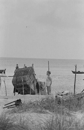 Prerower Strand mit Badegästen, eine Frau beim Umziehen