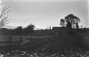 Chilenisch-deutscher Bauernhof : Blick über ein Feld auf einen Bauernhof.