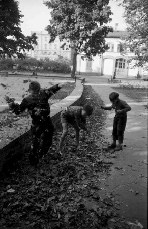 Spiele der Kinder mit Herbstlaub.