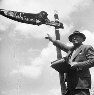 Herborn-Seelbach. Mann (Walzwerkbesitzer?) neben einem Wegweiser