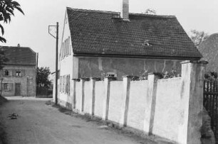Haus : Blick entlang einer Gartenmauer zu einem Haus