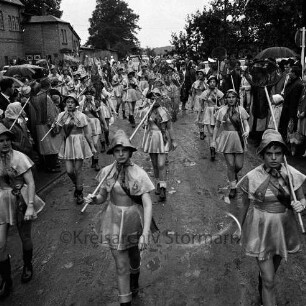 Karpfenfest: Umzug: Fischerinnengarde mit Keschern: an den Straßenrändern Zuschauer, mit Regenschirmen, 8. Oktober 1961