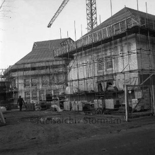 Amtsgericht: Königstraße: in Bau: Außenaufnahme: Rohbau mit Gerüsten, Plastikplanen: Dächer mit Lattung: Arbeiter: mehrere Palettengebinde mit Klinkern, Holzbalken, Pfützen: Baukran: im Vordergrund Straße Woldenhorn, Bauzaun