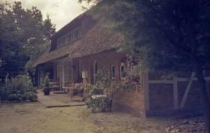 Hermann-Claudius-Weg / Ecke Poststraße: Reetdachhaus mit Trapezgauben: Traufseite mit Eingangstür: Briefkasten, Terrasse, Sitzgruppe: Giebelwand mit Fachwerk