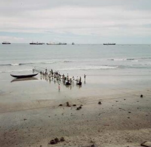 Accra, Beach : Accra (Ghana). Einholen eines Fischernetzes am Strand. Im Hintergrund Frachtschiffe auf Reede, 28. März 1959