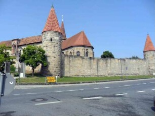 Ansicht von Ostsüdosten mit Kirche über Kirchhofmauer sowie Südost und Nordost-Rundturm über ehemaligen Grabenbereich