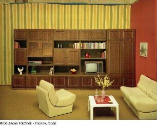 Anbauwand "Christina" : Wohnzimmermöbel (1976; VEB Möbelkombinat Berlin (MKB)). Ansicht mit Anbauwand, Couchtisch und Sitzgruppe