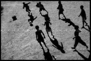 Fußballspielende Kinder und ihre Schatten (Prämiertes Foto Sonderthema: Fußball-Fieber)
