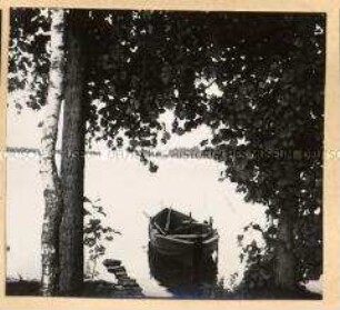 Blick vom Ufer aus auf ein kleines Ruderboot in einem großen See in Masuren