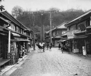 Yokohama (Japan). Straßenszene mit Blick zum 100-Stufen-Teehaus