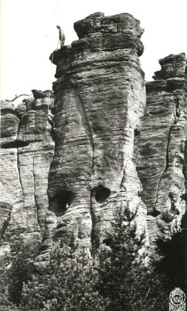 Böhmische Schweiz ( České Švýcarsko), Eiland (Ostrov). Emporturm (Vztyčená věž). Seilschaft Ehrhardt Renger an der Kante über dem 2. Ring des Alten Weges (VIIa). Blick aus dem Tal zum Massiv
