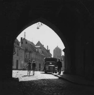 Stralsund. Blick durch einen Torbogen auf eine Straße, im Hintergrund Turm der St.-Jakobi-Kirche