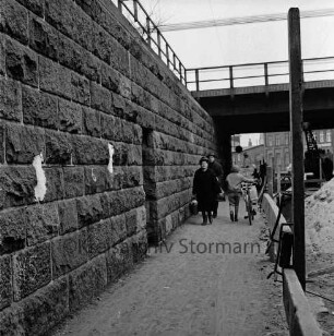 Pölitzer Weg: Bahnunterführung: Bau der Kanalisation: rechts Baustelle mit Bagger und Sandhaufen: in der Mitte Fußgänger: im Hintergrund Gebäude