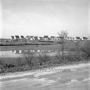 vorne Segeberger Chaussee, dahinter der Königsteich, im Hintergrund Wohngebäude der Straße An der Königswiese