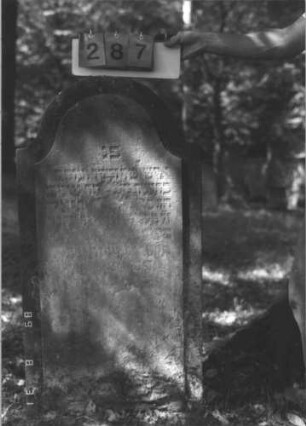 Grabstein 287 (Index: 99609924) Material: Sandstein Zustand: stark verwittert, ageblättert, weitgehender Textverlust Maße HxBxT: 112x60x11 cm Beschreibung: Stele, Konvexbogenabschluß, Schriftfeld erhaben: Grabstein 287