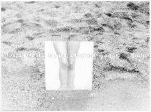 Fuß auf einem Spiegel am Strand (Altersgruppe 14-17)