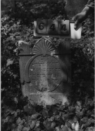 Grabstein 544 (Index: 99789123) Material: Sandstein Zustand: stärker verwittert im unteren Teil Maße HxBxT: 63x40x8 cm Besonderheit: Kindergrab: Grabstein 544