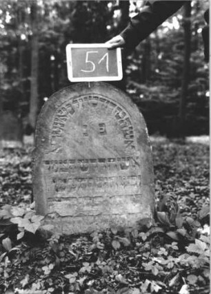 Grabstein 51 (Index: 99895070) Material: Sandstein Zustand: gut, im unteren Teil abgeblättert, eingesunken Maße HxBxT: 77x56x7 cm Beschreibung: Stele mit eingezogenem Rundbogenabschluss: Grabstein 51