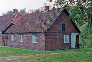 Gut Jersbek: Allee 2: traufständige Landarbeiterkate aus Backstein: Straßenfront, Giebelseite mit Eingangstür: links Arbeiterwohnhaus [angeschnitten]