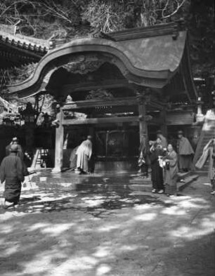 Nara. Kasuga-Taisha (768 gegründet, 1853 letzter Neubau des 20-Jahre-Turnus). Besucher am überdachten Wasserbecken zur Reinigungszeremonie vor dem Schreinbesuch