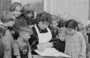 Eine Kindergärtnerin liest Kindern vor