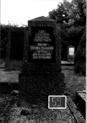 Grabstein 59 (Index: 100110276) Material: Granit, Schriftplatte Marmor Zustand: leicht verwittert Maße HxBxT: 130x54x27 cm Beschreibung: Stele, Sockel, obeliskenartiger Abschluß, Schriftplatte mit eingezogenem falchen Abschluß: Grabstein 59