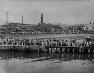 Hafen von San Francisco : Blick vom Meer auf den Hafen von San Francisco. Auf dem Landungssteg und an der Kaimauer stehen zahlreichen Menschen versammelt