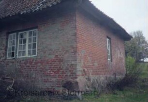 Blumendorf: "Lange Kate": Mehrfamilienkate aus Backstein mit Ziegeldach: Teilansicht: Giebelseite und Hausecke: Feldsteinfundament