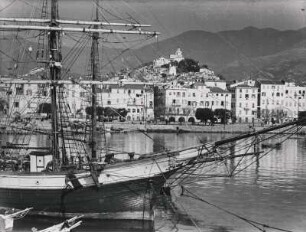 San Remo. Italien. Italienische Riviera. Boote liegen im Hafen vor Anker. Im Vordergrund ein Segelschiff. Im Hintergrund das Panorama der Stadt