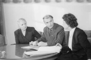 Reportage aus dem Ministerium für Volksbildung der DDR : Paul Wandel (Minister für Volksbildung und Jugend) mit den Staatssekretärinnen des Ministeriums für Volksbildung Elisabeth Zaisser (links) und Ruth Fabisch (rechts)
