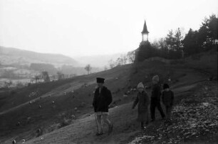 Campulung: Hügelkette mit weidenden Schafen, Hintergrund Kirche, Vordergrund Personen
